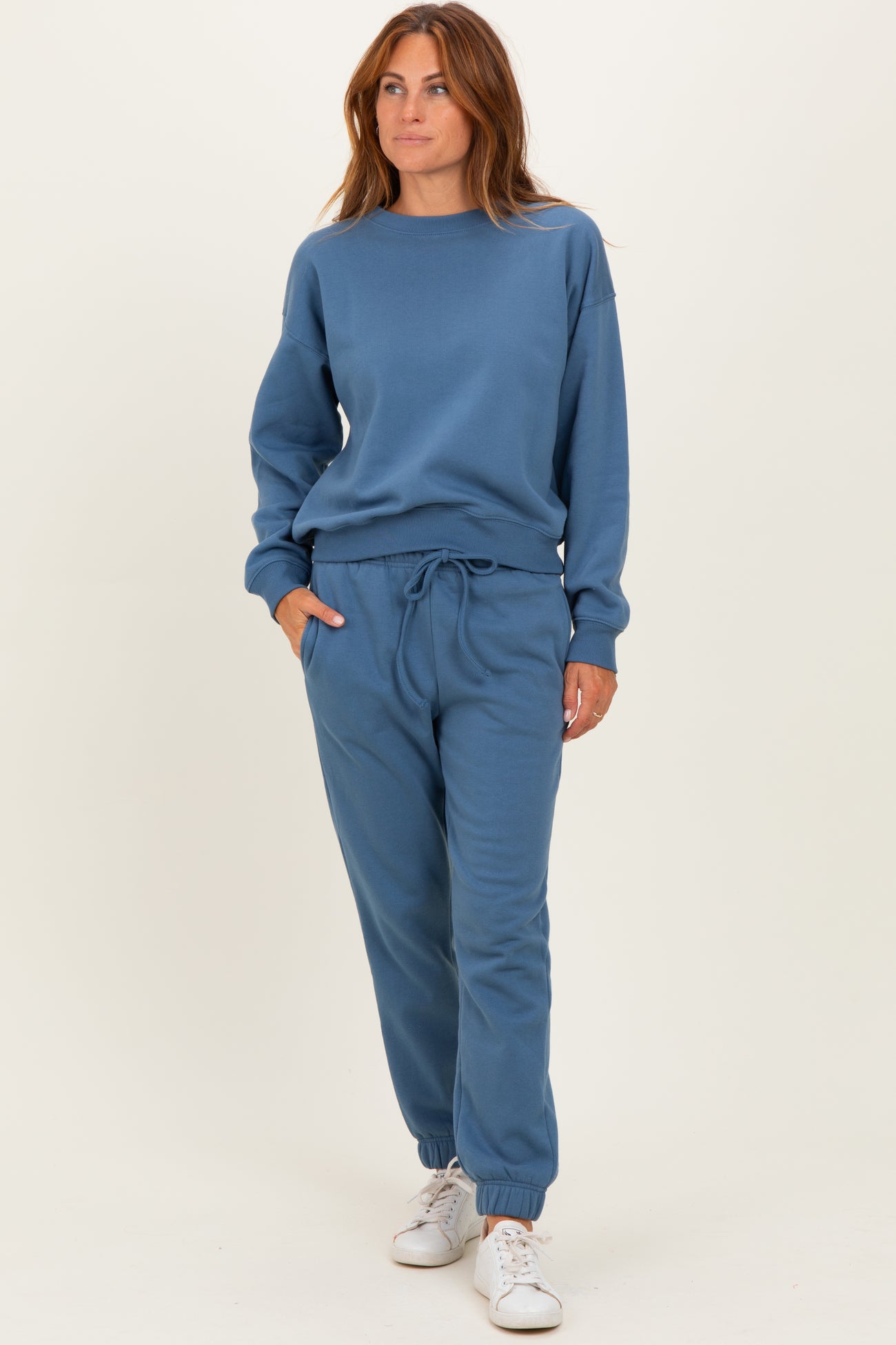 woman wearing a blue matching sweatshirt and jogger set with a relaxed fit and drawstring waistband