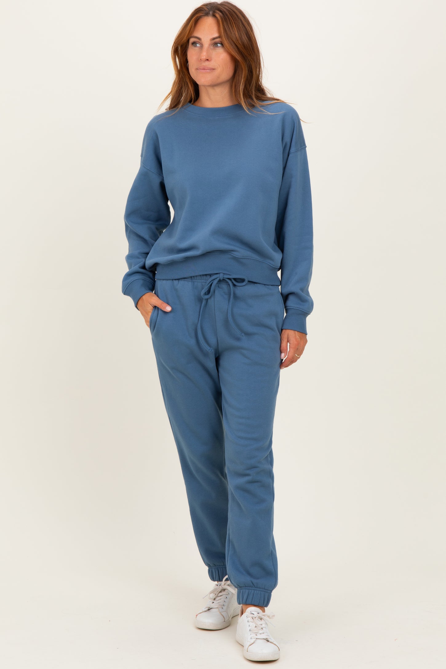 woman wearing a blue matching sweatshirt and jogger set with a relaxed fit and drawstring waistband