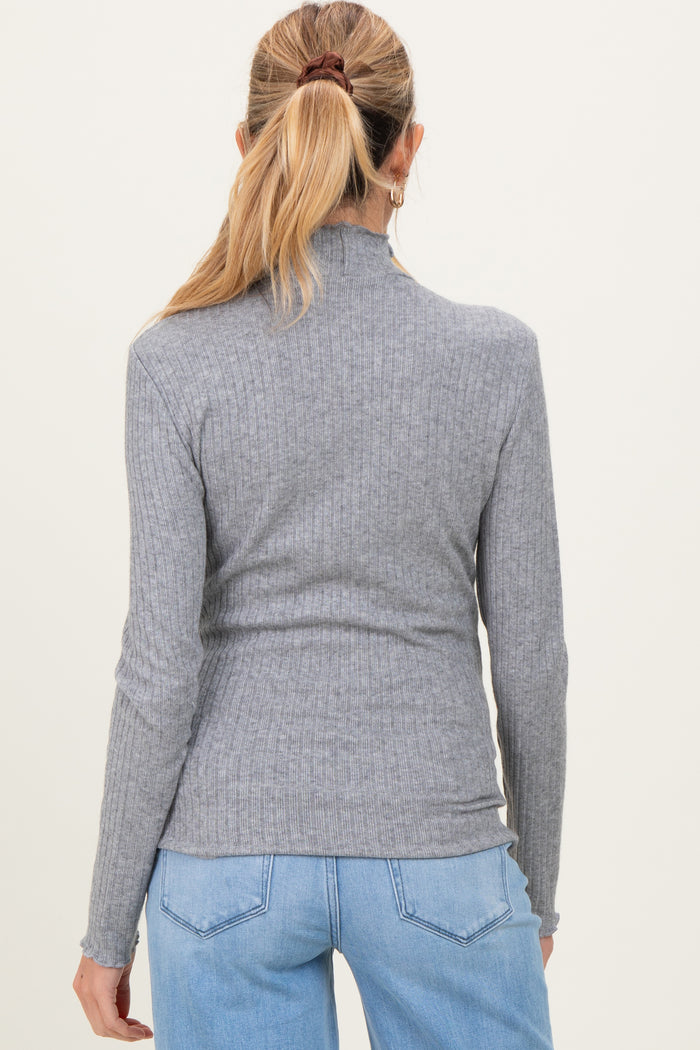 woman wearing a grey ribbed maternity turtleneck top, viewed from the back with long sleeves and a fitted style