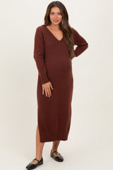 woman wearing a rust-colored long sleeve maternity dress with a v-neck and side slit, showing her baby bump