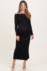woman wearing a black off-the-shoulder maternity maxi dress showing her baby bump
