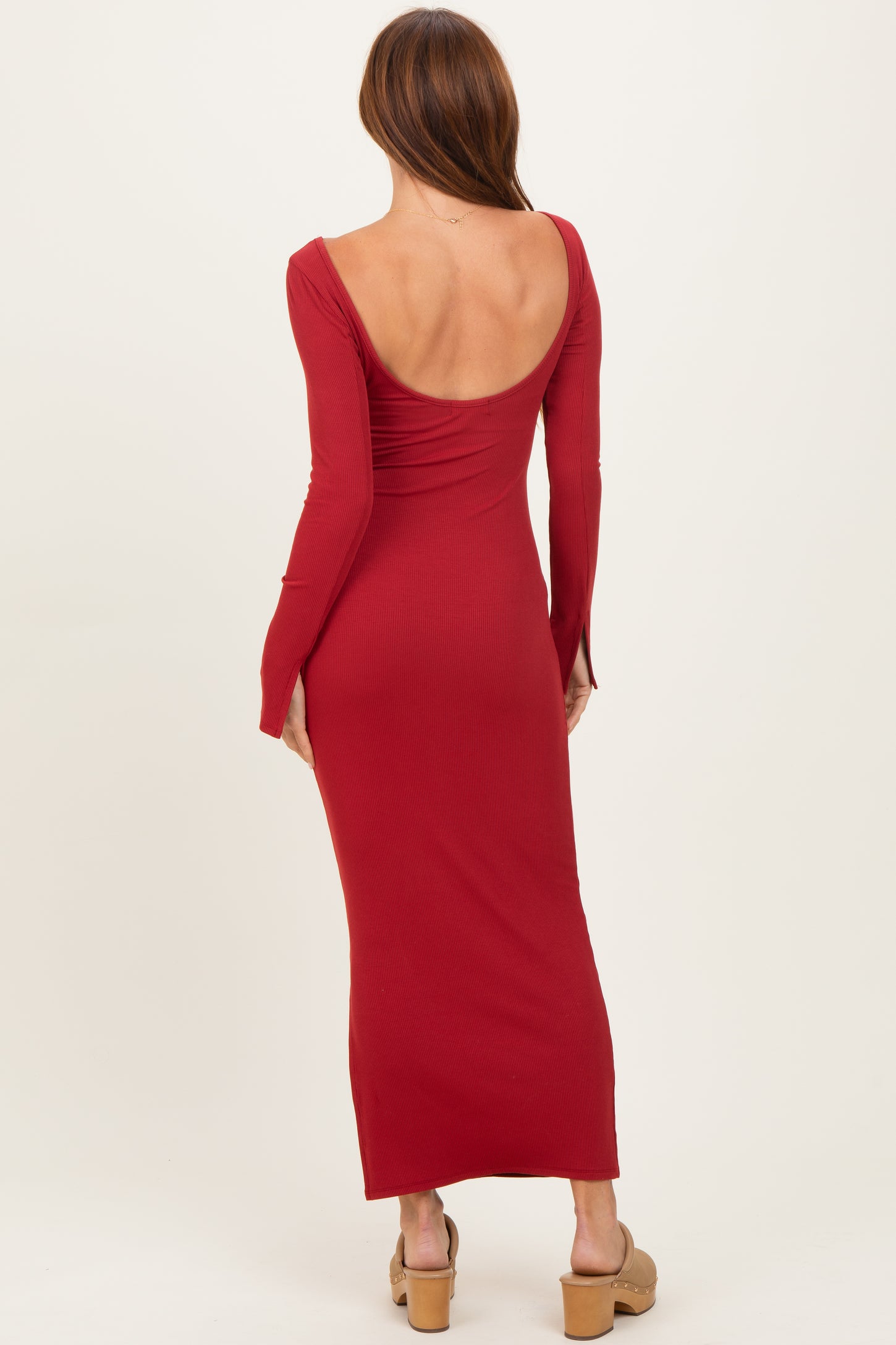 woman wearing a red ribbed long sleeve maxi dress with a low back and fitted silhouette