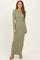 woman wearing a long sleeve olive green ribbed maxi dress with a side slit and smiling at the camera