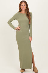 woman wearing a long sleeve olive green ribbed maxi dress with a side slit and tan clogs