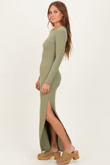 woman wearing a ribbed olive green maxi dress with long sleeves and side slits