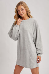 woman wearing a gray long sleeve sweatshirt dress with a relaxed fit and side pockets