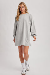 woman wearing a gray long sleeve sweatshirt dress with a relaxed fit and balloon sleeves