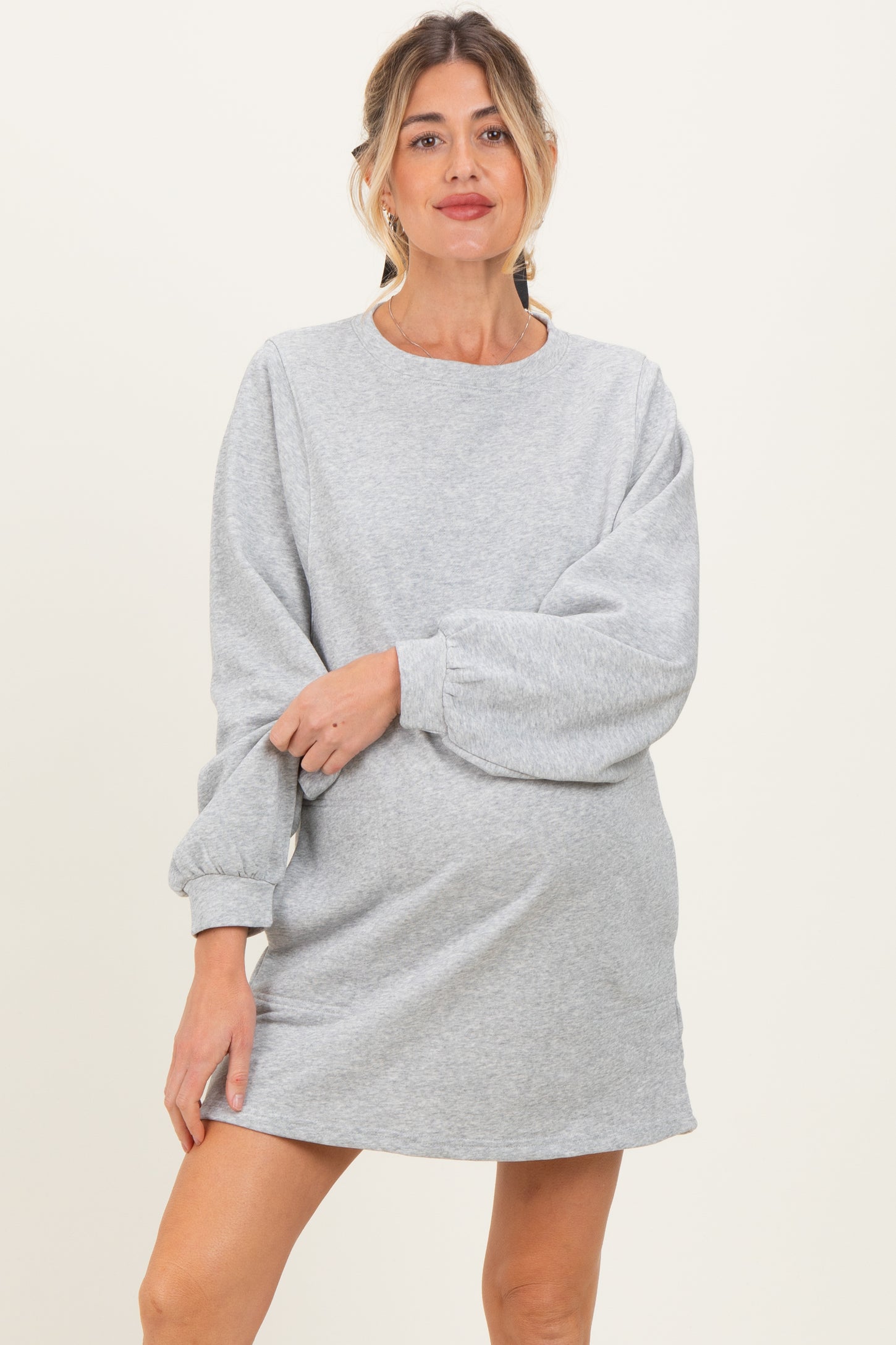 woman wearing a gray maternity sweatshirt dress with balloon sleeves and a visible baby bump