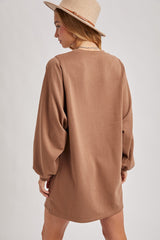 woman wearing a brown oversized sweatshirt dress with long sleeves, viewed from the back