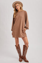 woman wearing a brown long sleeve sweatshirt dress with pockets and brown embroidered cowboy boots
