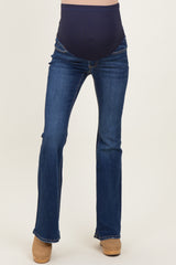 woman wearing dark blue maternity jeans with a belly panel and flared legs