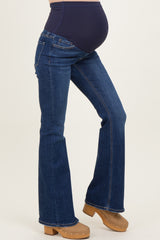 woman wearing dark blue maternity flared jeans with a supportive over-the-belly band and showing a baby bump