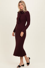 woman wearing a maroon ribbed midi dress with a bow tie detail and long sleeves