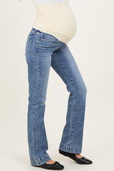 woman wearing light blue maternity jeans with a fitted belly panel and a visible baby bump