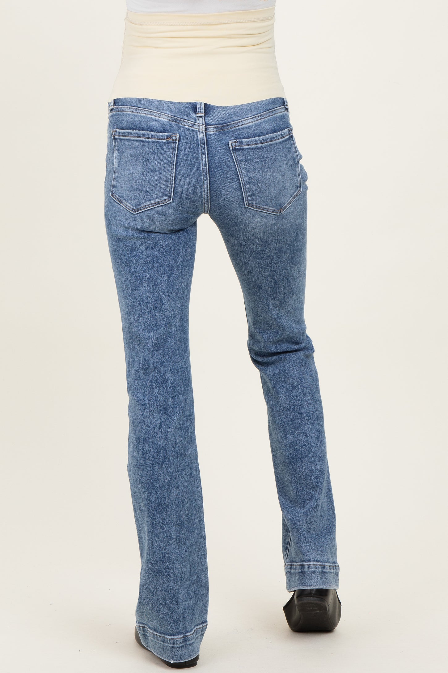 maternity wear light blue flared jeans shown from the back