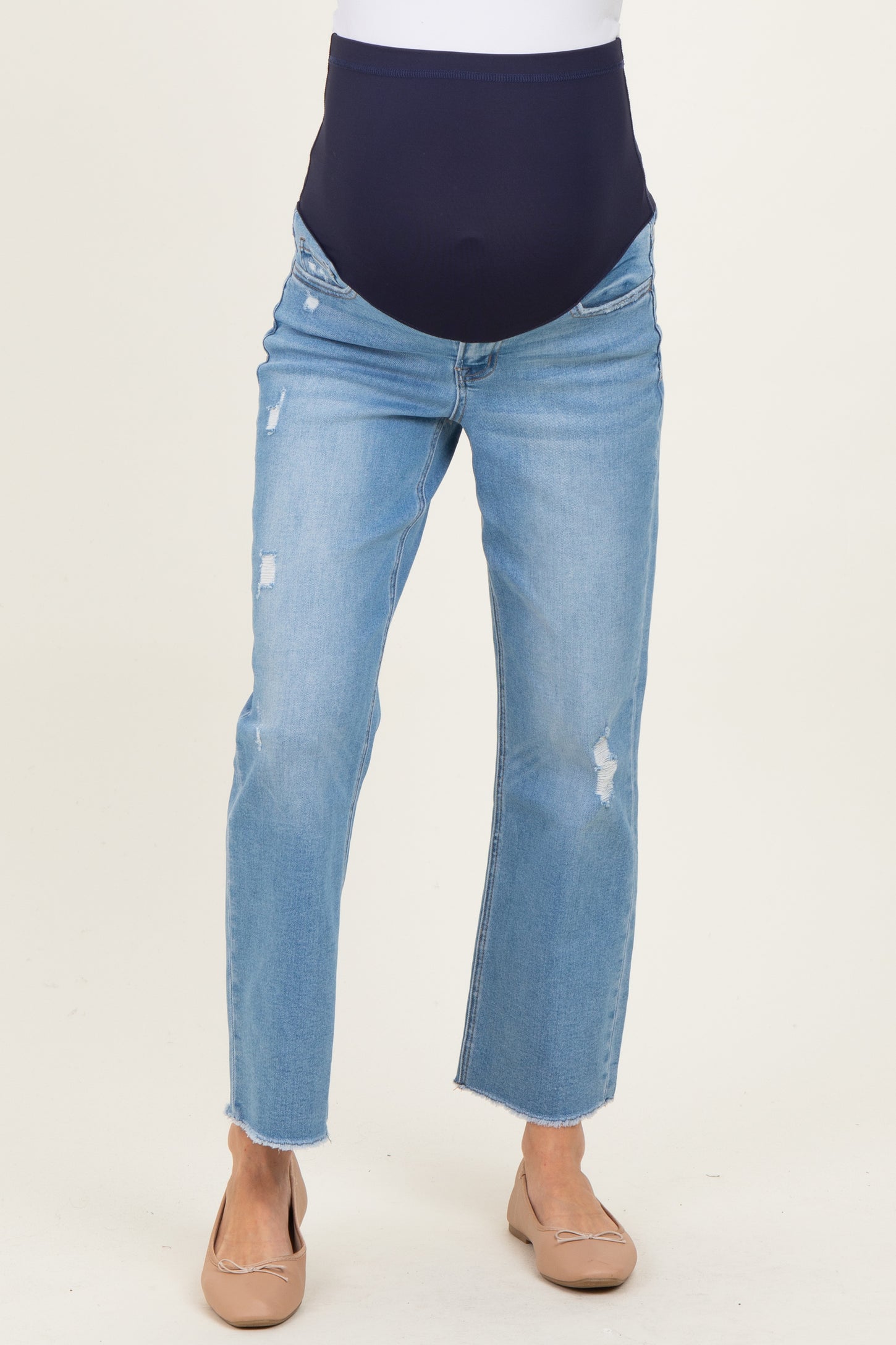 woman wearing a pair of light blue maternity jeans with a navy stretchy waistband and distressed details
