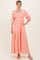 woman wearing a coral tiered maxi dress with puff sleeves and floral embroidery