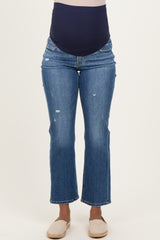 woman wearing blue distressed maternity jeans with a navy over-the-bump waistband
