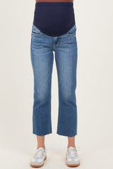 woman wearing a pair of light blue cropped maternity jeans with a navy over-the-bump panel and frayed hems
