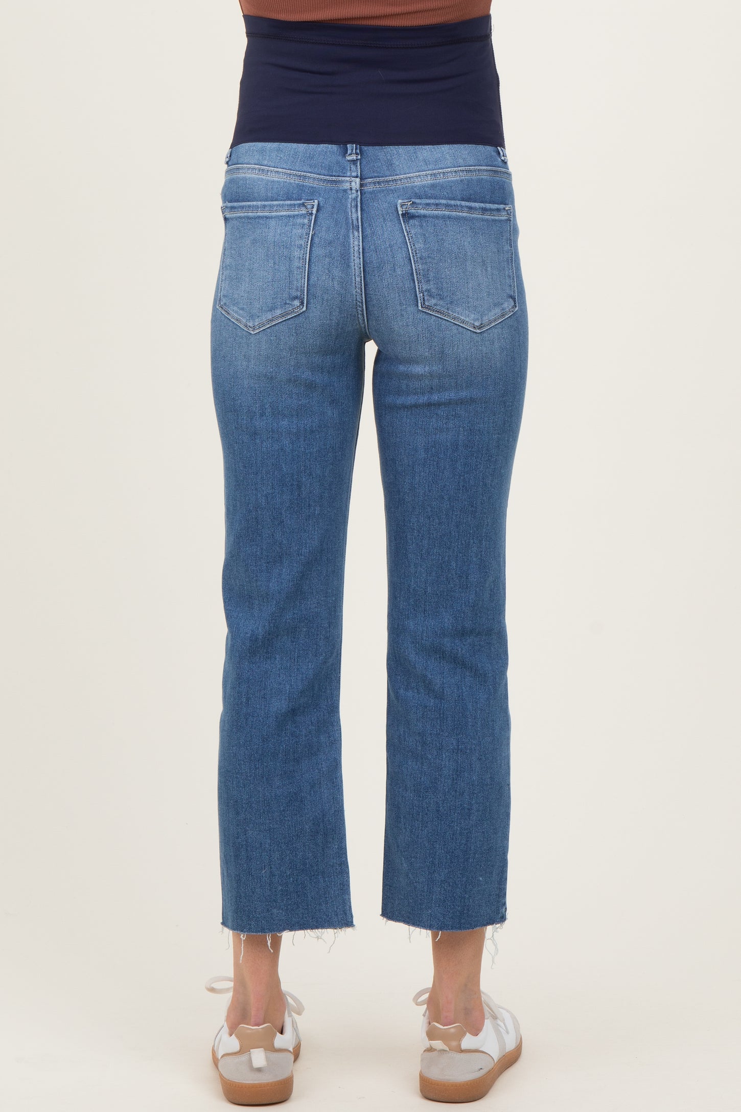 woman wearing blue maternity cropped jeans with a stretchy waistband, seen from the back