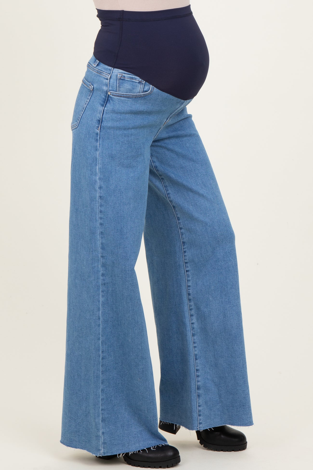woman wearing light blue wide-leg maternity jeans with a dark waistband and visible baby bump