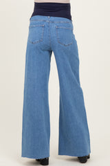 woman wearing light blue maternity wide-leg jeans with a frayed hem, showing the back view