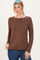 woman wearing a brown long sleeve top with a scoop neckline and denim jeans, styled with a headscarf