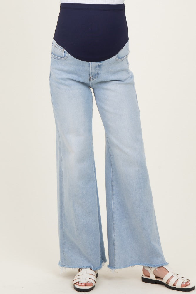 woman wearing light wash maternity flared jeans with a navy blue over-the-bump waistband