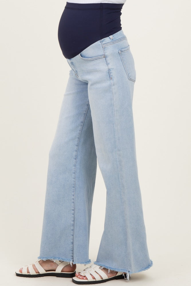 woman wearing light blue maternity flared jeans with a visible baby bump