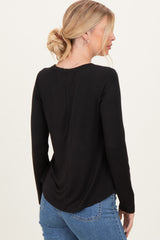woman wearing a black long sleeve top with a rounded hem and back seam, paired with light blue jeans