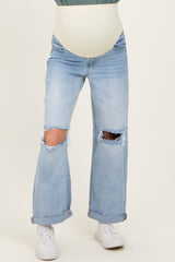 woman wearing light blue distressed maternity jeans with a cream-colored belly panel and rolled cuffs