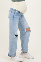 woman wearing light blue distressed maternity jeans with a supportive belly band and a visible baby bump
