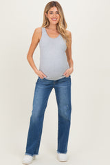 woman wearing a light gray ribbed maternity tank top and blue maternity jeans, showing her baby bump