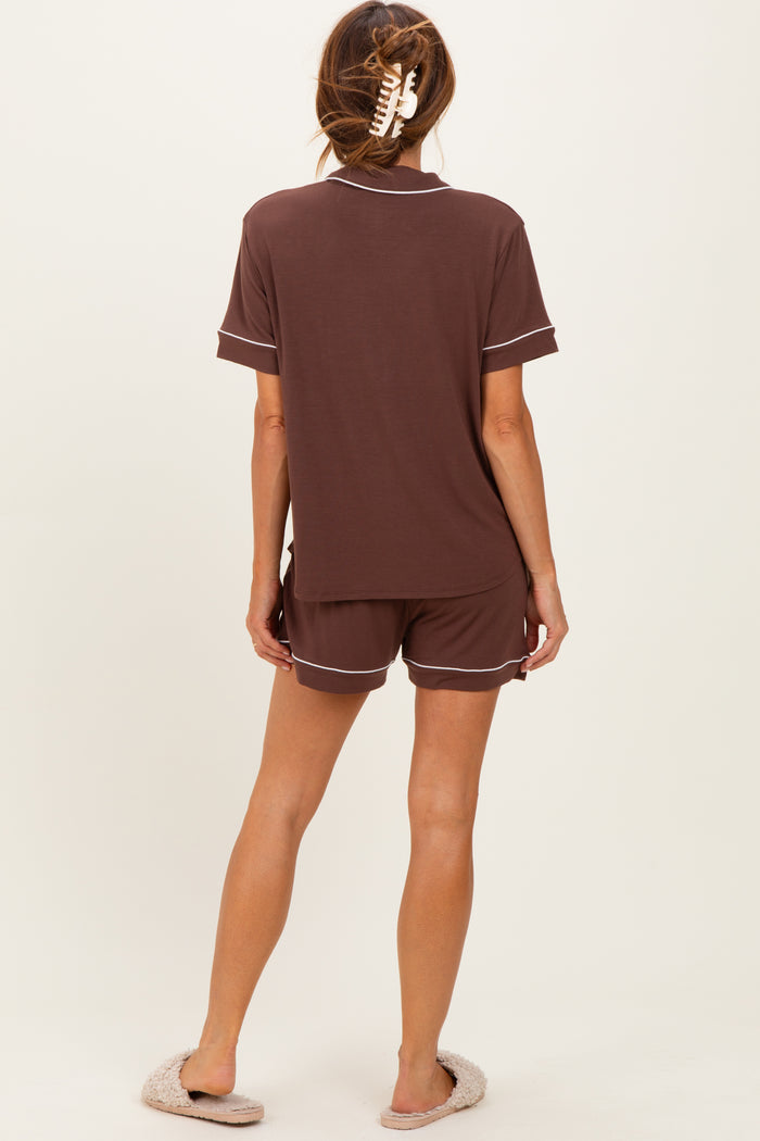 woman wearing a dark brown short sleeve pajama set with contrast piping and comfortable shorts