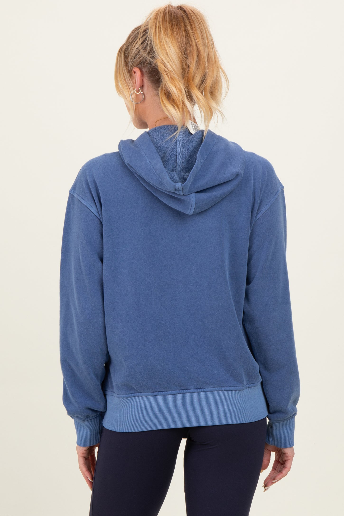 woman wearing a blue maternity hoodie with a relaxed fit and a hood, seen from the back