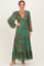 woman wearing a green floral maxi dress with long sleeves, deep v-neck, and tiered ruffles
