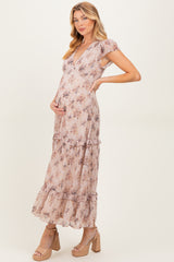 woman wearing a floral print maternity maxi dress with tiered ruffles and a v-neck, holding her baby bump