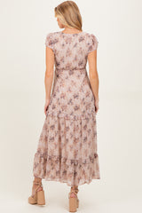 woman wearing a floral print maternity maxi dress with short sleeves and ruffled hem, showing a baby bump