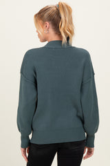 woman wearing a dark teal maternity sweater with balloon sleeves, viewed from the back