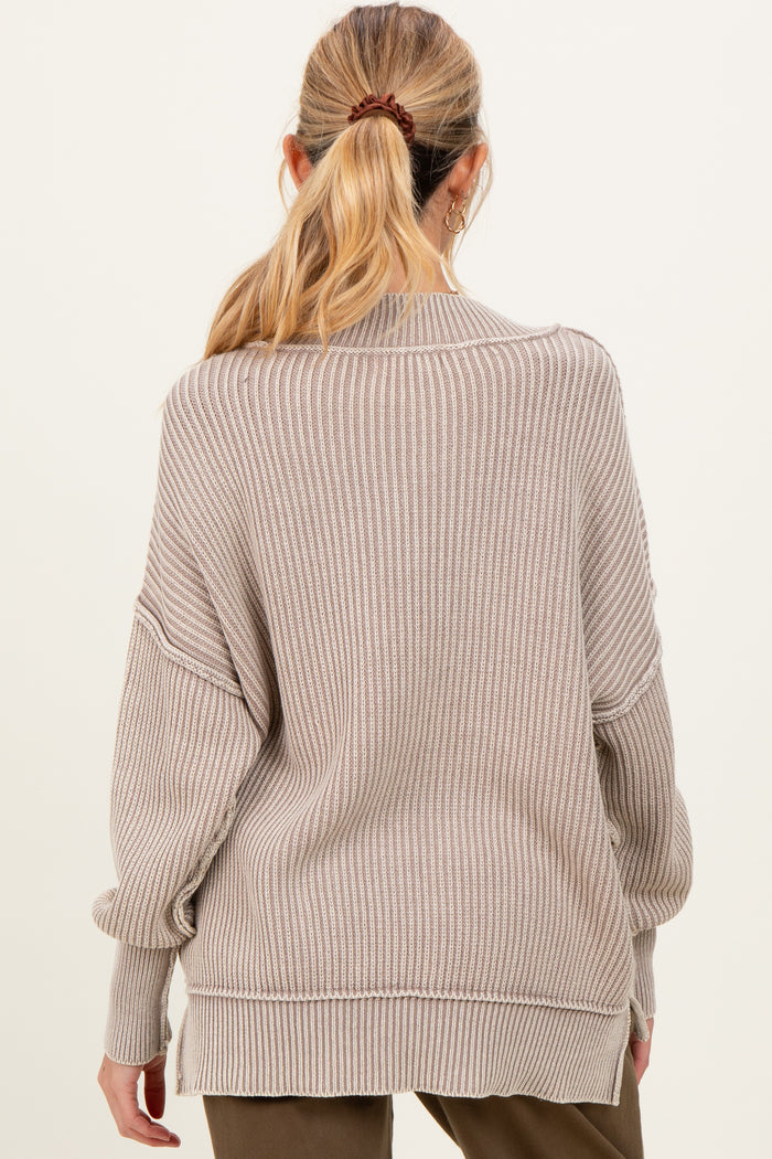 woman wearing a cozy beige striped maternity sweater with a relaxed fit and dropped shoulders, viewed from the back