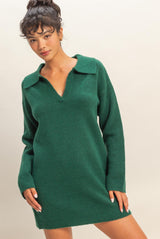 woman wearing a green sweater dress with a collar and long sleeves, posing with one hand on her hip