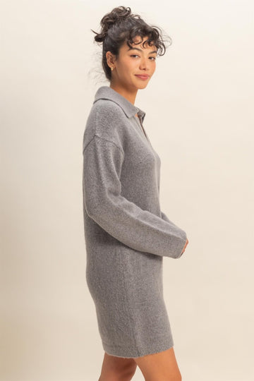woman wearing a grey oversized knitted sweater dress with a collar and long sleeves