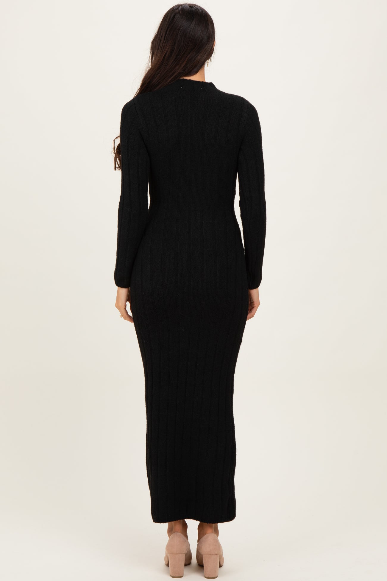 woman wearing a black ribbed knit maxi dress with long sleeves, shown from the back