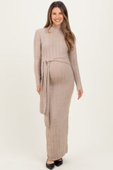 woman wearing a beige long sleeve ribbed maternity dress with a tie at the waist and a visible baby bump