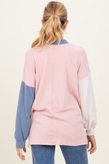 woman wearing a pink, blue, and white striped long sleeve maternity top with a relaxed fit