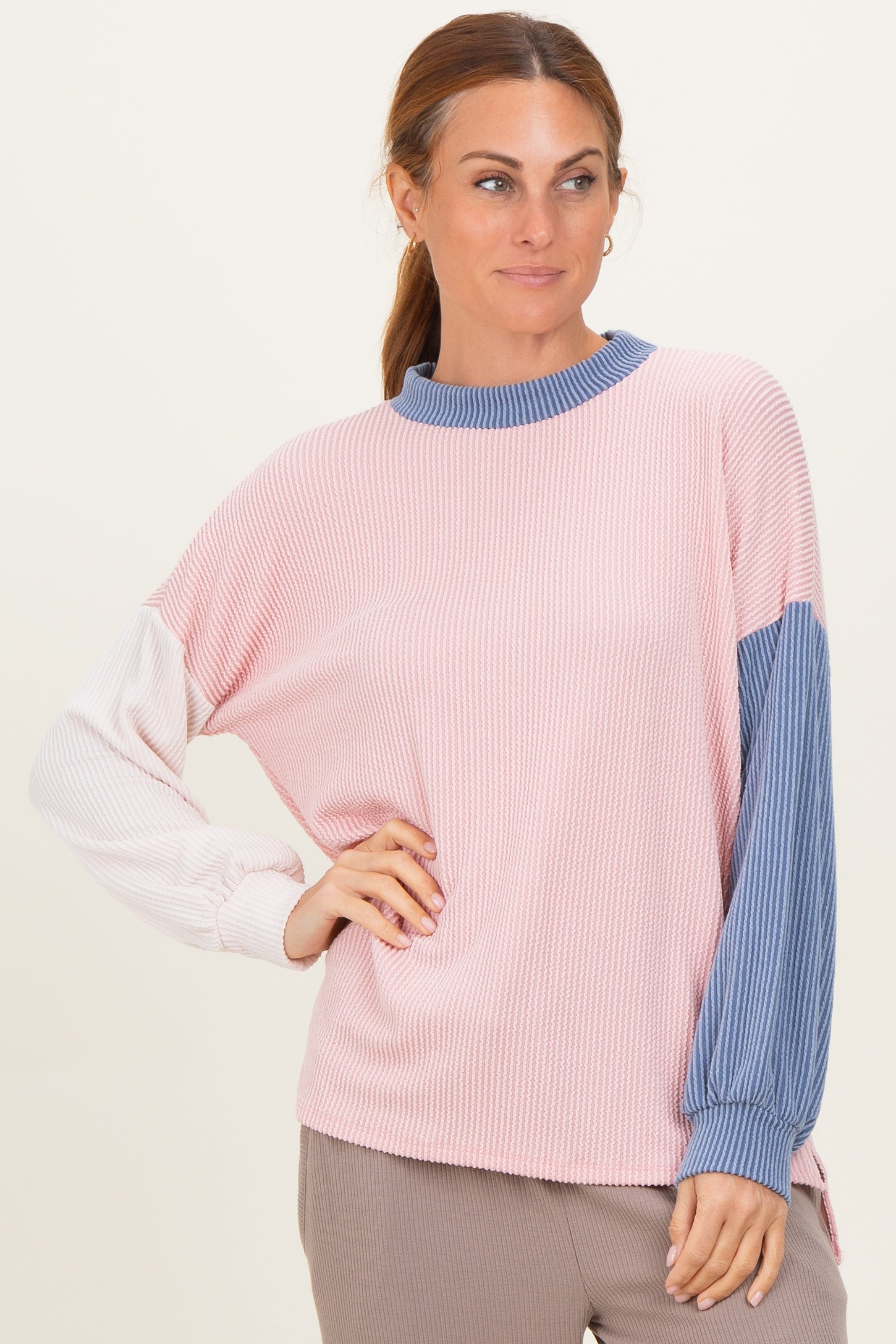woman wearing a pink and blue color block long sleeve top with ribbed texture and relaxed fit