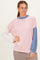 woman wearing a pink and blue color block long sleeve top with ribbed texture and relaxed fit