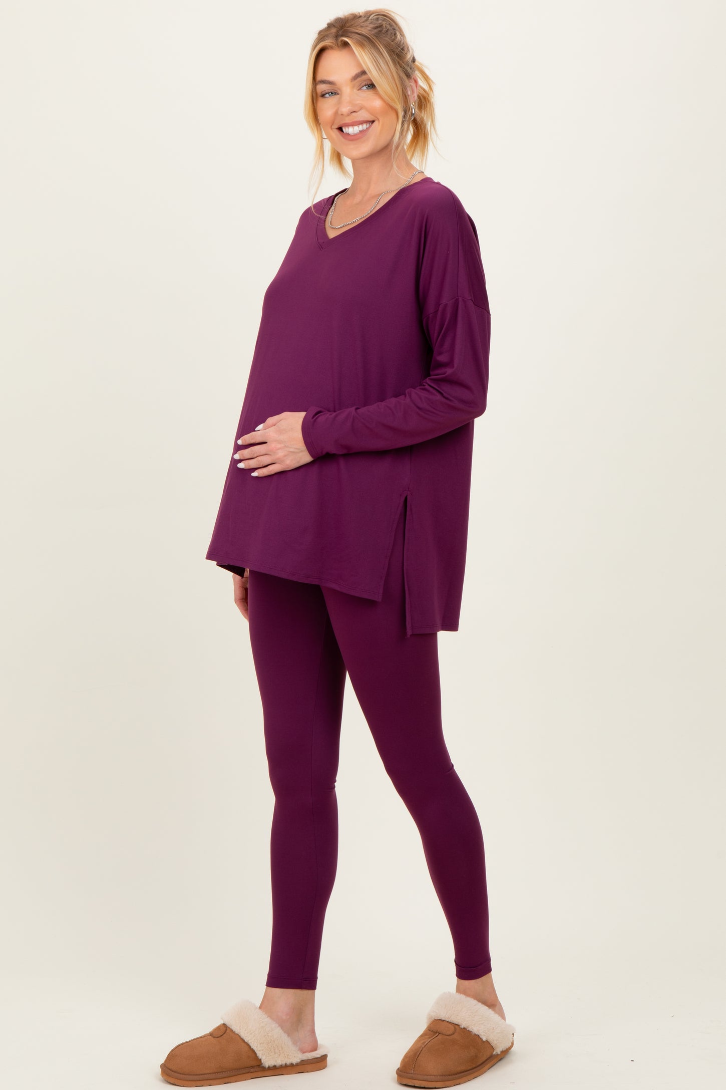 woman wearing a purple maternity lounge set with a long sleeve top and leggings, highlighting her baby bump