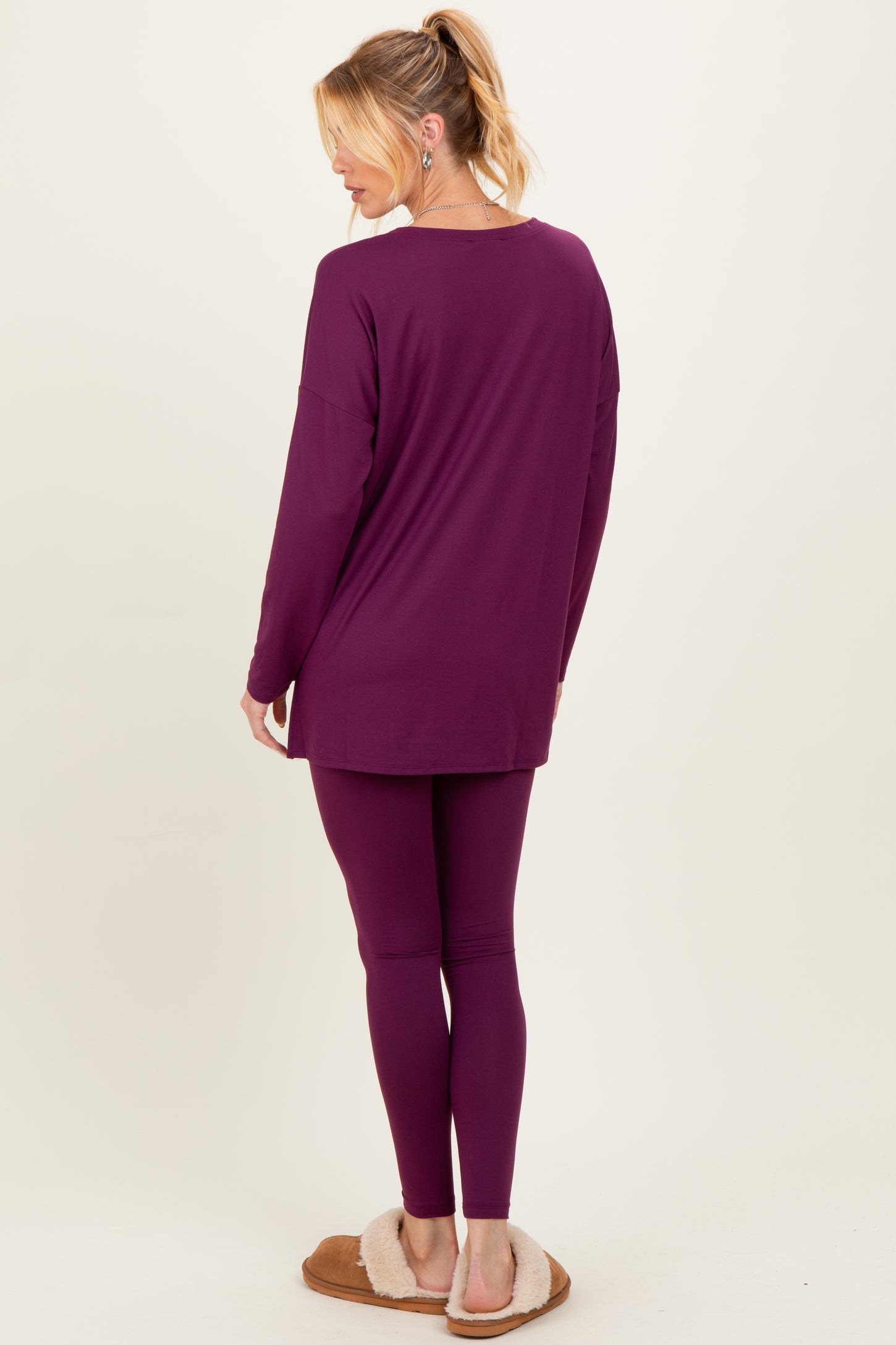 woman wearing a purple maternity loungewear set consisting of a long sleeve top and leggings, showing a relaxed fit