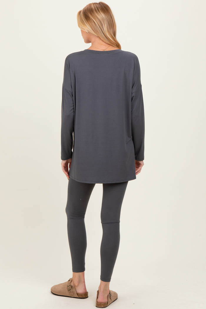 woman wearing a gray long sleeve maternity top and matching leggings, viewed from the back